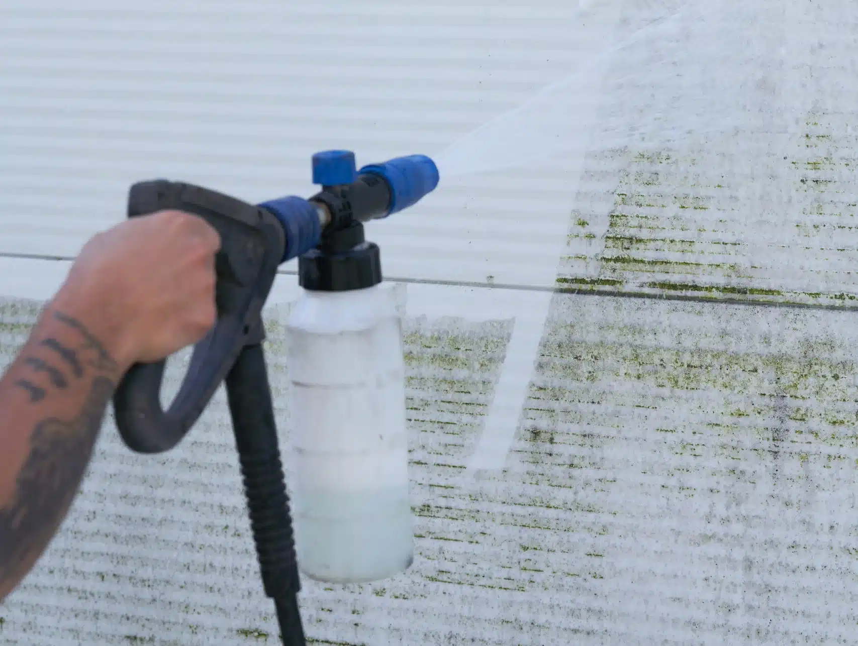 Bilde av en høytrykksspyler med vaskemiddel som vasker en vegg